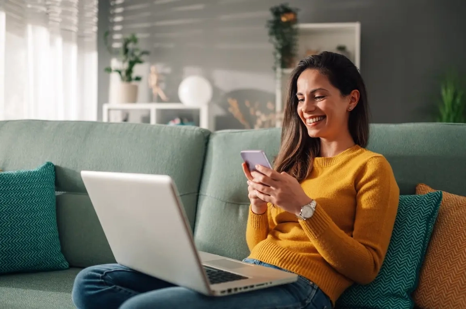 uśmiechnięta kobieta patrząca się na telefon
