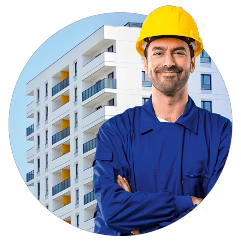 Uśmiechnięty pracownik budowy stojący przed blokiem