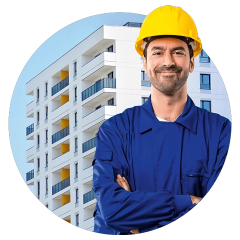 Mężczyzna w kasku budowlanym, stojący obok bloku mieszkalnego